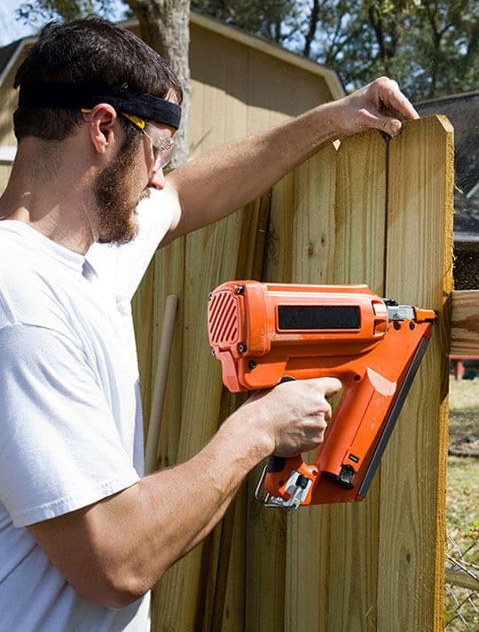 Man in White Shirt Fixing Fence - Big Easy Fences